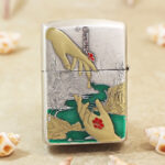 Close-up of the red spider lily engraving and gold-tone accents on the Zippo Armor lighter