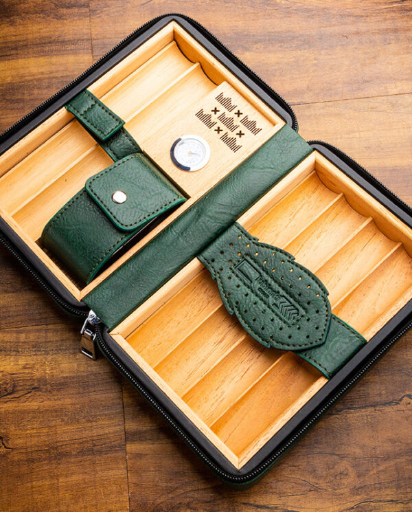 CH-022-01 Green leather travel humidor with two wooden compartments and a pocket strap, shown open on a wooden surface.