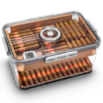 Transparent cigar humidor full of cigars, with a central round humidifier dial and a digital hygrometer on the lid.