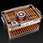 Open glass-top cigar humidor with neatly arranged cigars and a built-in hygrometer display inside the box.