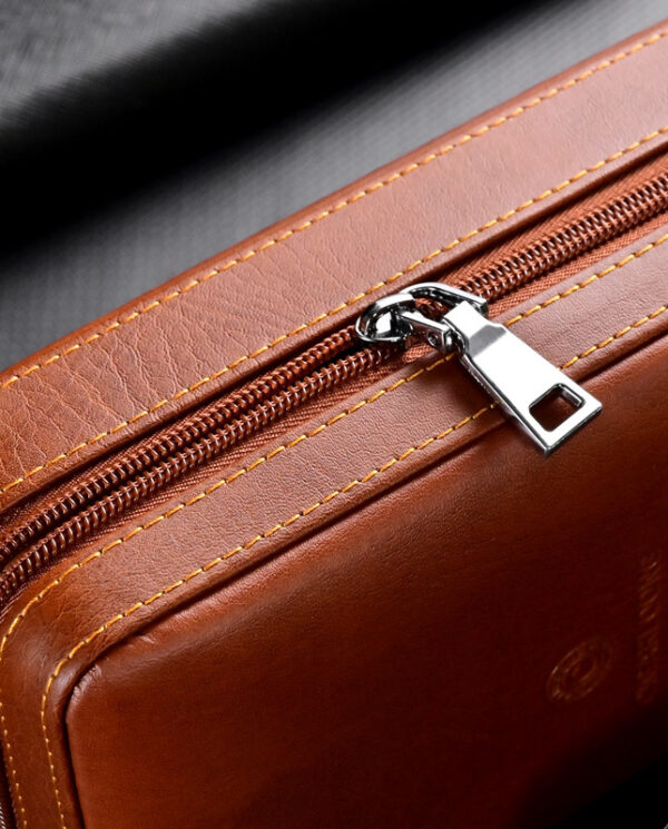 Close-up of a brown leather bag zipper with a silver pull and yellow stitching edge margins.