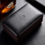 Black leather zippered case or wallet with red contrast stitching and embossed logo on top surface, photographed on a dark textured background.