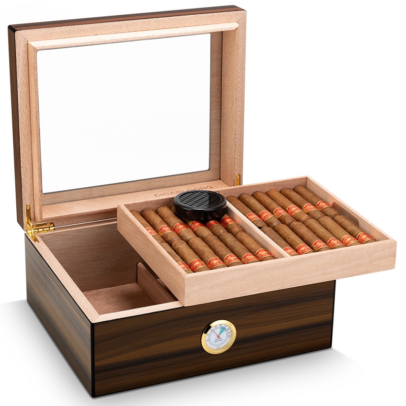 Wooden cigar humidor with lid open, showing two trays of cigars and a humidifier on top, plus a built-in hygrometer on the front panel