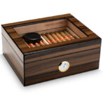 Wooden cigar humidor with cigars arranged inside and a humidity gauge on the front lid side