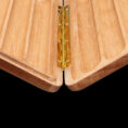 Close-up of a brass hinge joining two light wood panels in a folding joint.