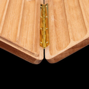 Close-up of a brass hinge joining two light wood panels in a folding joint.