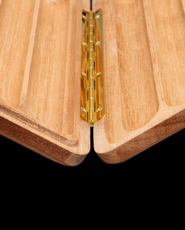 CH004-02 Close-up of a brass hinge joining two light wood panels in a folding joint.