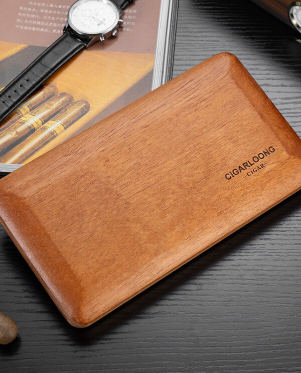 CH004 Wooden cigar humidor on a dark desk with a wristwatch and a magazine nearby.