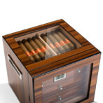 Wooden cigar humidor with a glass top, cigars arranged inside.