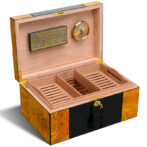 Open wooden cigar humidor with three divided trays, brass hinges, and a brass hygrometer on the lid (humidor interior shown).