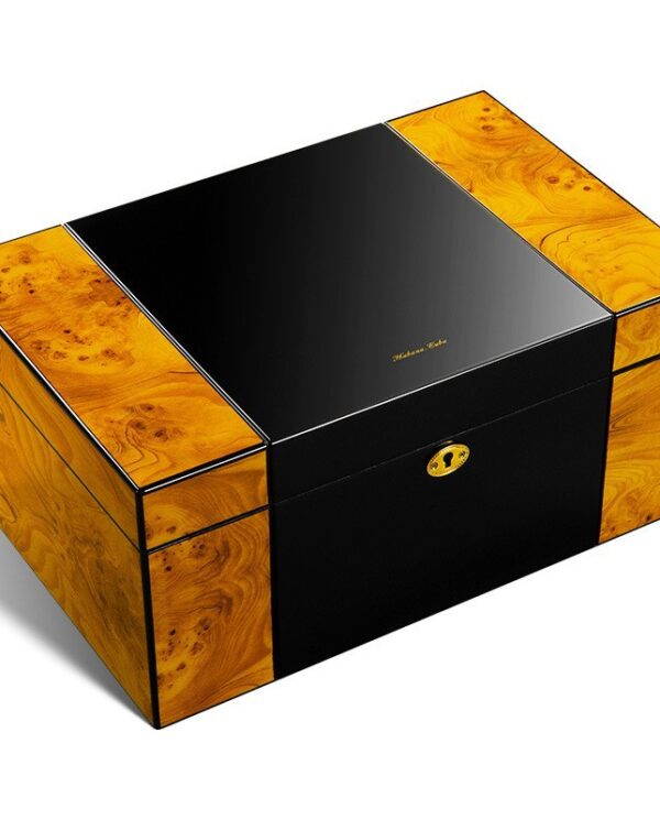 Luxurious black and burl wood cigar humidor with a gold lock and wood inlays on the corners.
