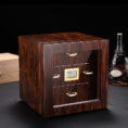 Wooden cabinet-style device with a small digital humidity display showing 70% and gold drawer handles on a dark surface.