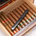 Open cedar humidor drawer with cigars and rectangular humidifier