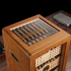 Wooden cigar humidor with a glass lid showing neatly arranged cigars inside.