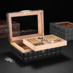 Open luxury cigar humidor with a slide-out tray of cigars and a mirrored lid revealing a leather-quilted exterior.