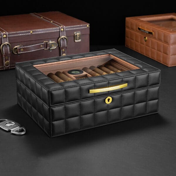 CH014 Black quilted leather cigar humidor with a glass lid, holding several cigars and a small humidifier disk inside, gold front plate visible.