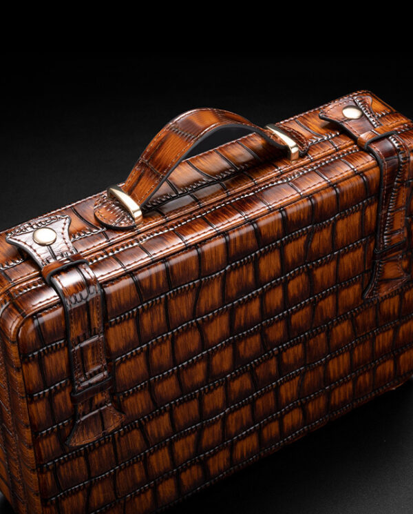 CH015-01 Brown textured leather briefcase with a crocodile pattern, brass hardware, and a top handle on a dark background