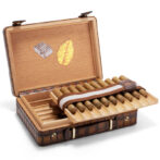 Open wooden cigar humidor with a row of cigars arranged in a sliding tray and a brown strap inside.