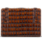 Brown crocodile-embossed leather clutch with two vertical strap tabs on top edge, rectangular shape, no visible branding.