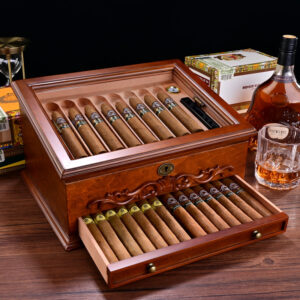 Open wooden cigar humidor with cigars arranged in rows; drawer pulled out showing more cigars.