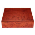 Rectangular wooden box with a polished reddish-brown finish and visible grain patterns, closed against a white background.