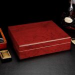 Red-brown piano lacquer wooden cigar humidor on a dark surface