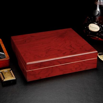 Red-brown piano lacquer wooden cigar humidor on a dark surface