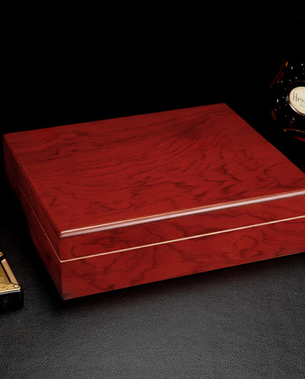 CH018 Polished red-brown wooden box on a black surface, with a bottle of Hennessy cognac in the background.