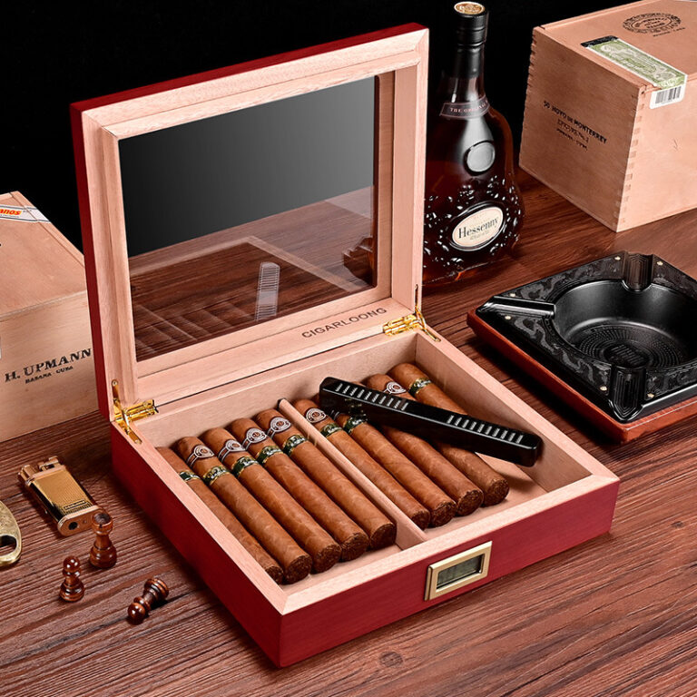 Open wooden cigar humidor filled with cigars, a black lighter rests on the lid, and a hygrometer/display sits inside the case.