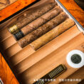 Wooden cigar humidor with several cigars and a digital hygrometer showing about 62% humidity (cigars not included).