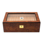 Wooden cigar humidor with a glass top showing lined interior and a small circular humidification device inside, plus a gold lock on the front.