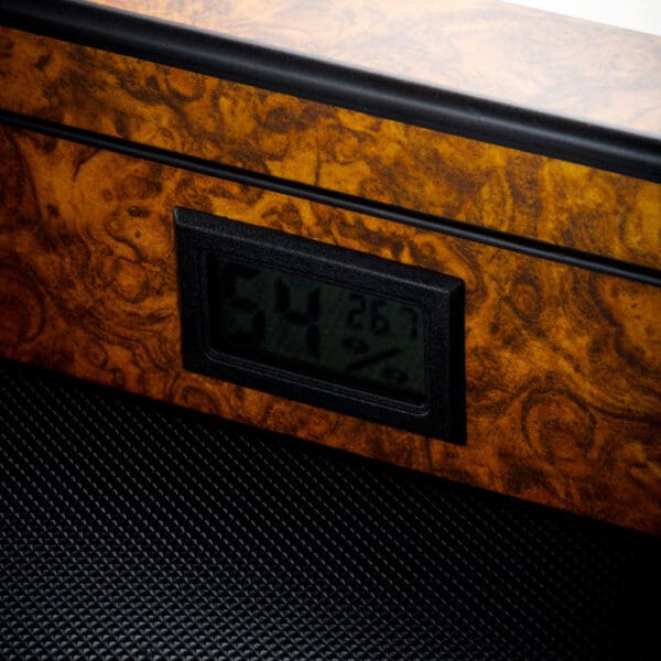 Digital humidity and temperature display embedded in a burl wood panel showing 54% and 26.7°C.