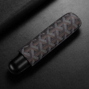 Slim device wrapped in a brown patterned fabric sleeve on a dark surface, showing a chevron-like design and black ends.