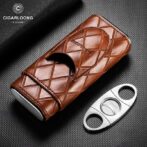 Brown quilted leather cigar case with a flap closure placed beside a metal cigar cutter on a textured black background.