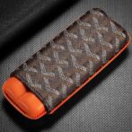 Brown patterned fabric case with orange interior, likely a glasses or accessory case on a textured surface.