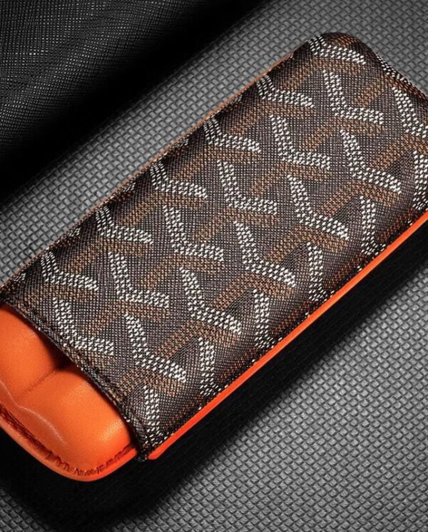 CL033-01 Brown patterned fabric case with orange interior, likely a glasses or accessory case on a textured surface.