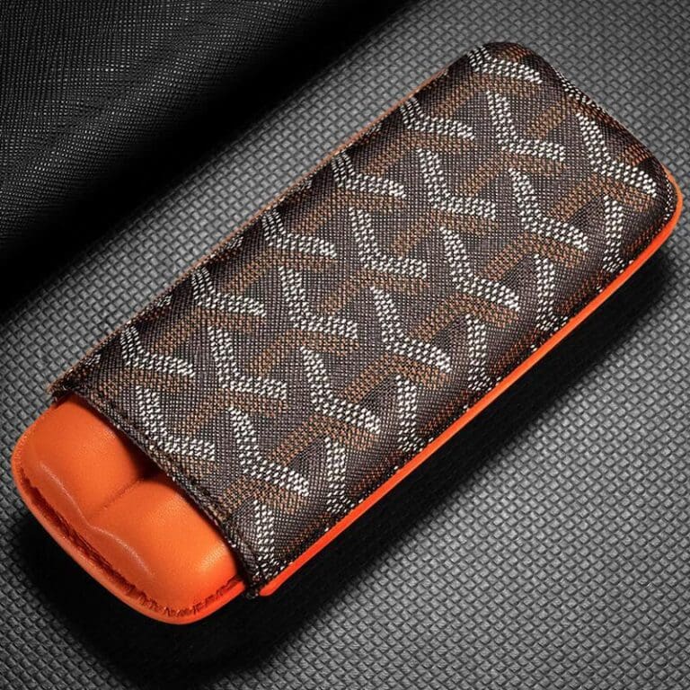 CL033-01 Brown patterned fabric case with orange interior, likely a glasses or accessory case on a textured surface.