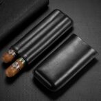 Black leather cigar case with two cigars partially removed, resting on a dark textured surface