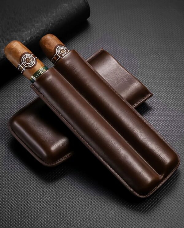Two cigars with light bands resting in a dark brown leather cigar case on a textured black surface.