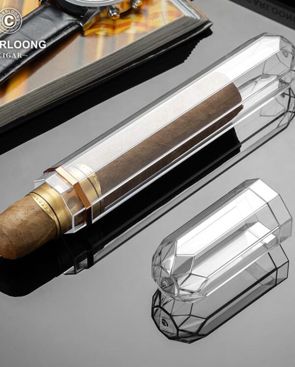 CL037-03 Transparent crystal cigar tube with a brown cigar inside, placed on a reflective black surface; brand logo visible in the corner.
