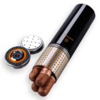 Black cylindrical cigar tube with a gold lattice sleeve, three cigars protruding from the open end, and two round caps beside it on a white background.