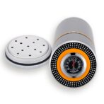Cigar humidor hygrometer device with a perforated metal cap and a circular dial showing humidity around an orange ring.