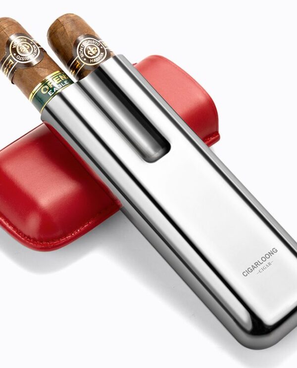 CL042-03 Stainless steel double-blade cigar cutter with two cigars resting on top and a red leather case behind it, angled diagonally.