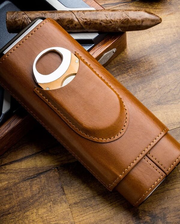 HY-3305L-01 Brown leather cigar case with a built-in circular cutter, resting a cigar on a wooden table.