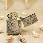 Open brass Zippo Armor lighter showing an alternate view of the skull and floral artwork