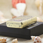 Beauty and Skulls brass Zippo Armor lighter displayed with Zippo packaging