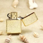 Open rear view of the golden arabesque Zippo and decorated lid