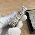 Angled hinge side covered in silver-tone arabesque detail