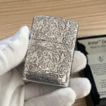 Silver-tone arabesque Zippo with dark recessed pattern and front serial panel No.10768