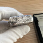 Top of the silver-tone Zippo lid with arabesque decoration